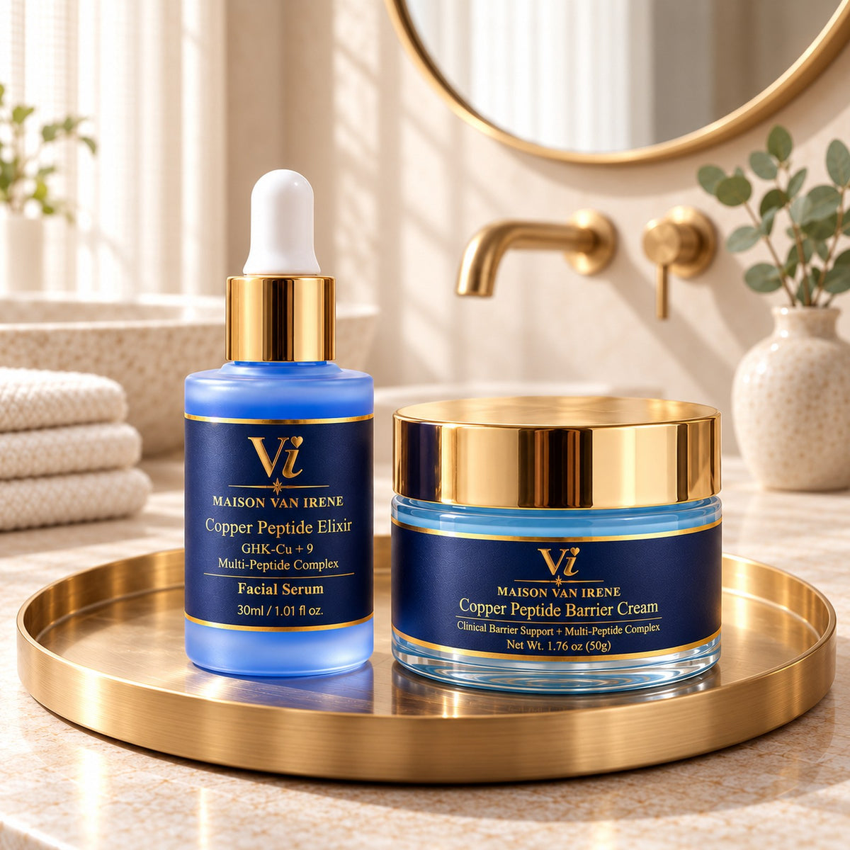 The Maison Van Irene Ritual — Copper Peptide Elixir bottle and Barrier Cream jar together on a brushed-brass tray on a stone vanity